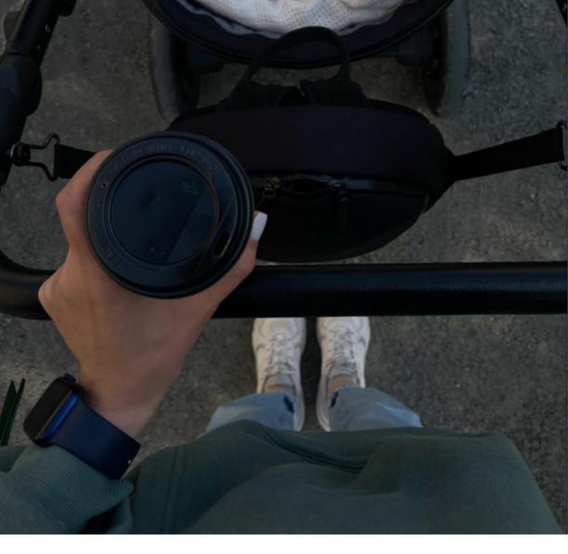 Top-down view of a parent walking with a stroller, holding an OnTheGo coffee cup